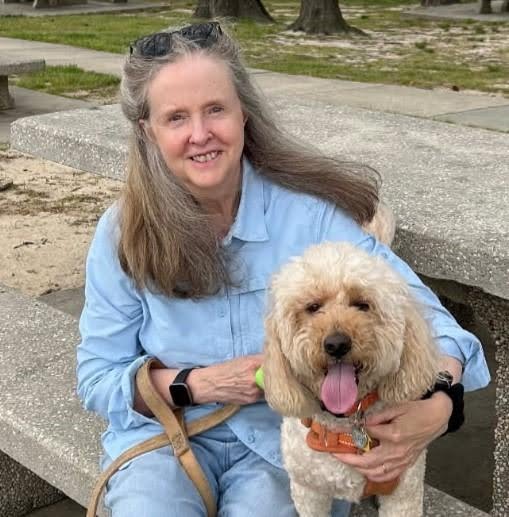 Lynn Offerman outside sitting with a fluffy golden dog