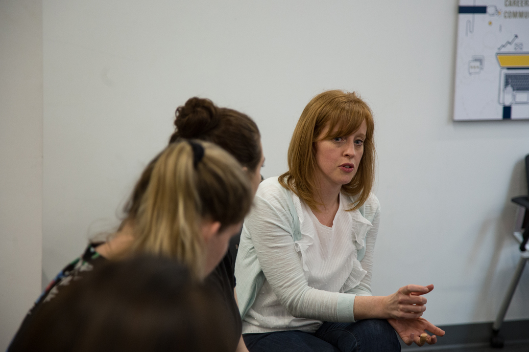 A woman speaks with Organizational Science and Communications students.