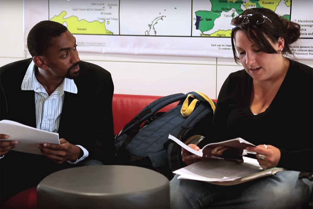 Two organizational sciences master's students discussing coursework and sitting on a couch